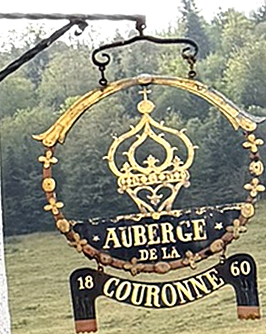 L'enseigne dorée de l'auberge : une couronne et l'inscription « Auberge de la Couronne 1860 »