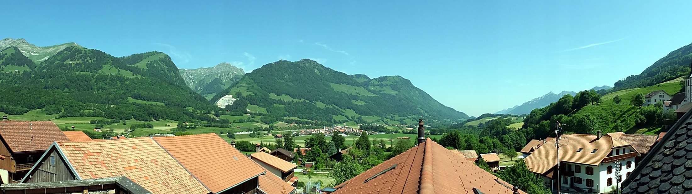 Panorama sur la vallée de l'Intyamon et les Préalpes, au-dessus des toits de Lessoc