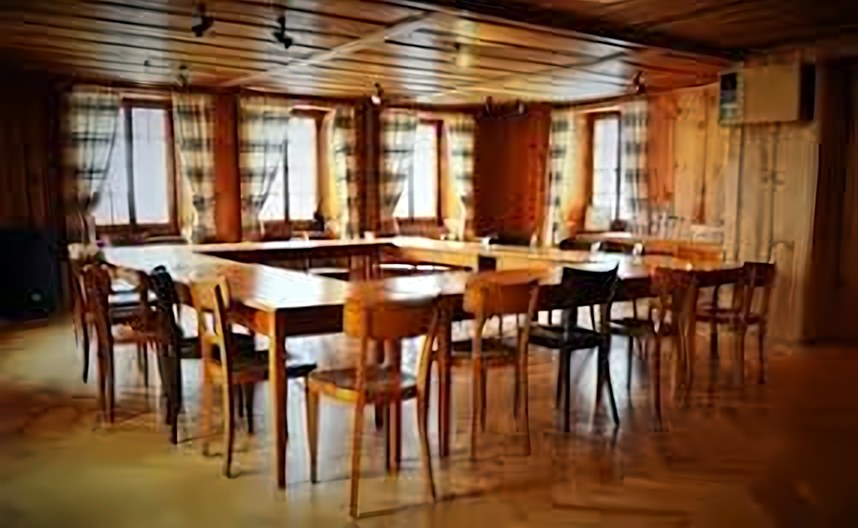 Salle dressée avec tables et chaises en bois